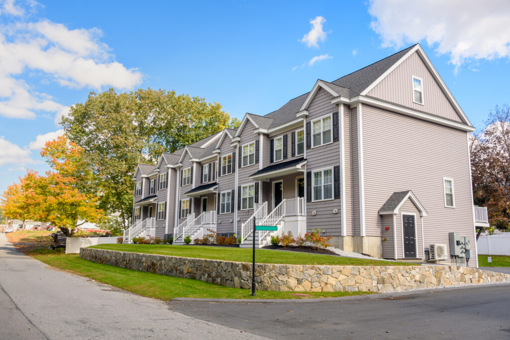 Newly built row houses in a housing development under blue sky in autumn.